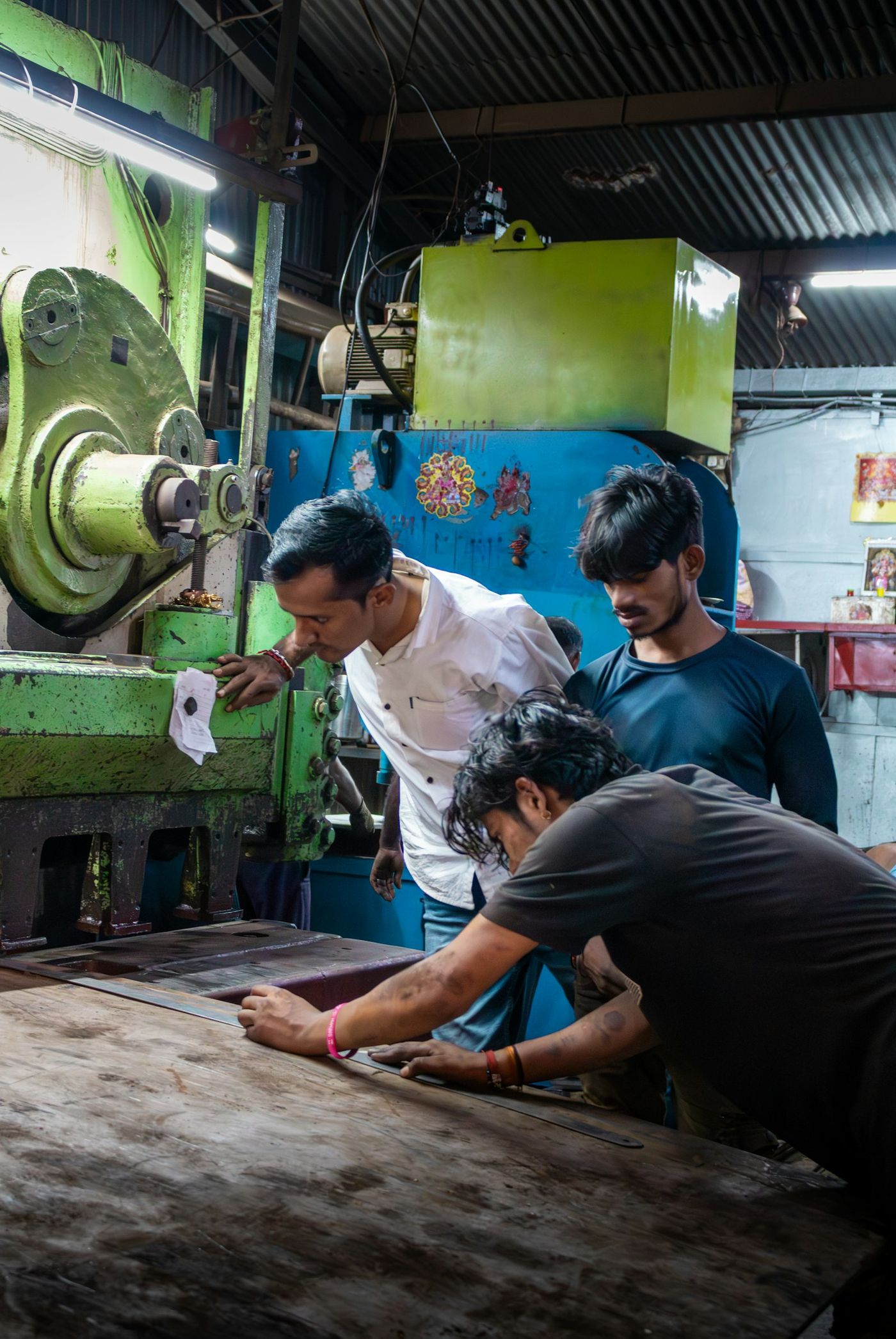 Young men learning to operate a machine